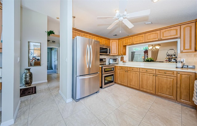 kitchen featuring ceiling fan with notable chandelier, a textured ceiling, backsplash, and stainless steel appliances