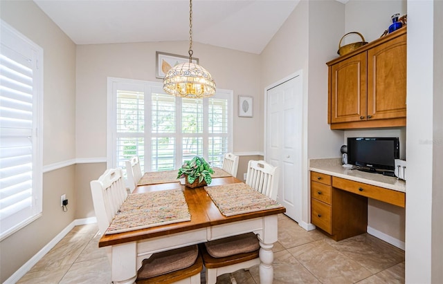 dining room with an inviting chandelier, built in desk, light tile patterned floors, and vaulted ceiling