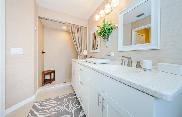 bathroom featuring a shower, a textured ceiling, vanity, and tile patterned floors