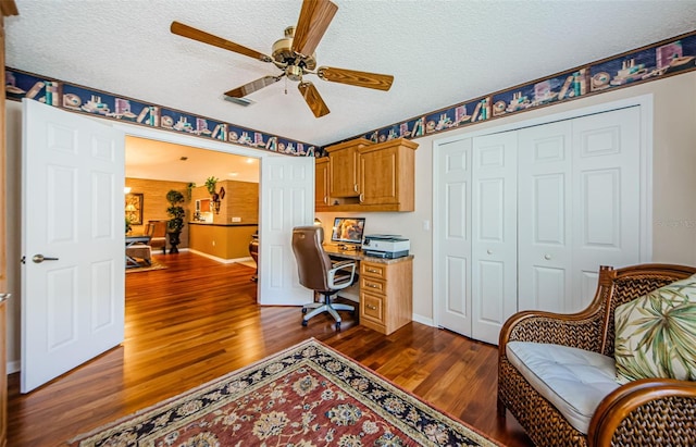 home office featuring a textured ceiling, ceiling fan, and dark wood-type flooring