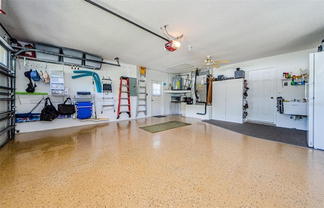 garage featuring ceiling fan, sink, and a garage door opener