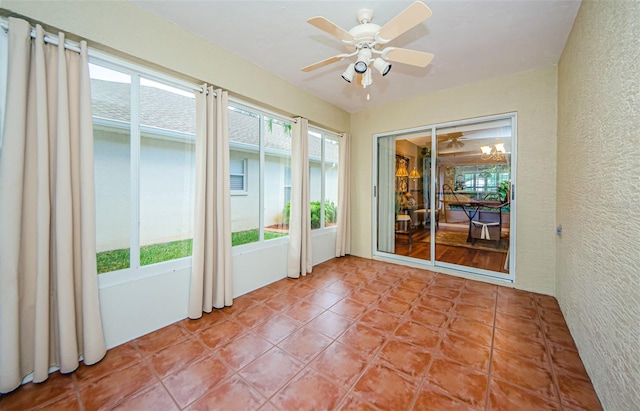 unfurnished sunroom with ceiling fan and a healthy amount of sunlight