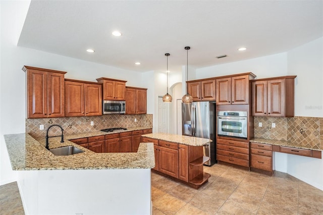 kitchen featuring sink, hanging light fixtures, stainless steel appliances, backsplash, and kitchen peninsula