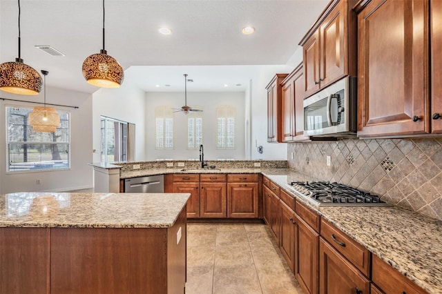 kitchen featuring ceiling fan, sink, hanging light fixtures, backsplash, and appliances with stainless steel finishes