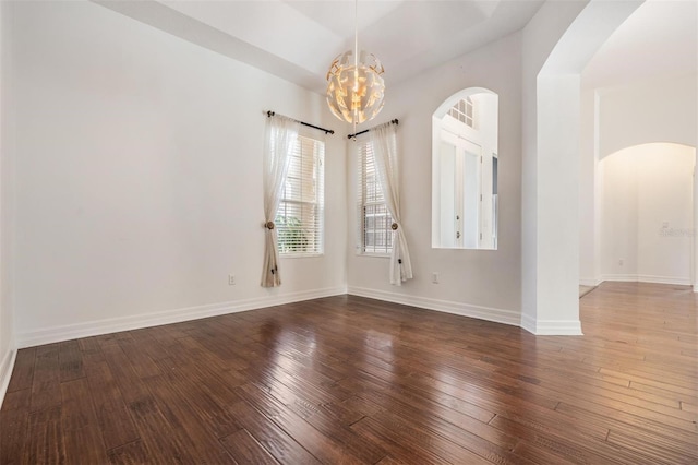 unfurnished room featuring hardwood / wood-style floors and a chandelier