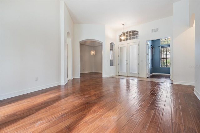 foyer featuring dark hardwood / wood-style flooring, a high ceiling, and a chandelier