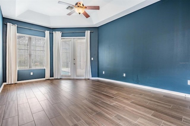 spare room with french doors, a raised ceiling, and ceiling fan