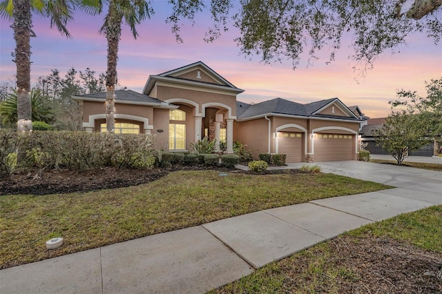 view of front of house with a garage and a lawn