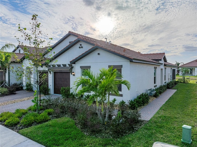 view of side of home with a yard and a garage