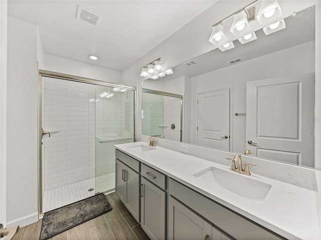 bathroom featuring wood-type flooring, vanity, and walk in shower