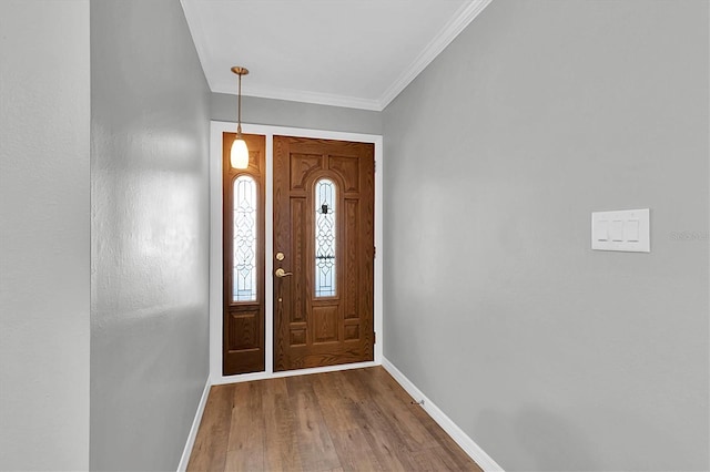 entrance foyer featuring baseboards, crown molding, and wood finished floors