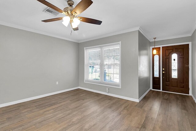 foyer entrance featuring baseboards, crown molding, visible vents, and wood finished floors