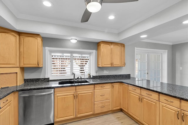 kitchen with a sink, ornamental molding, stainless steel dishwasher, light wood-type flooring, and dark stone counters