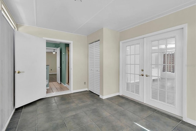 interior space featuring dark tile patterned floors, baseboards, and french doors