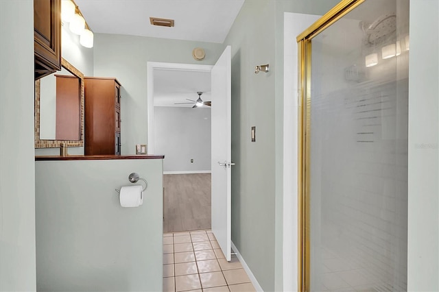 bathroom featuring ceiling fan, visible vents, baseboards, a shower stall, and tile patterned floors