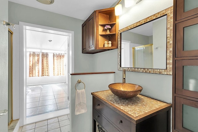 full bathroom with a shower with door, vanity, and tile patterned flooring