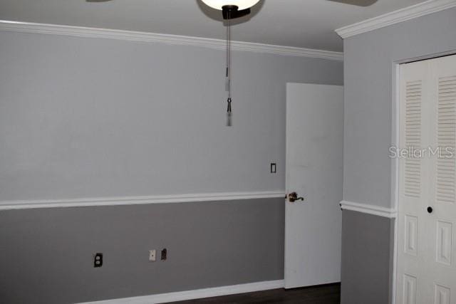 unfurnished bedroom featuring baseboards, ornamental molding, and a closet