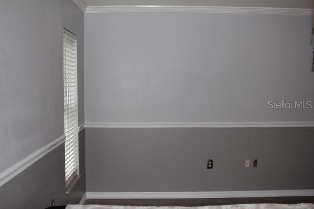 empty room featuring crown molding