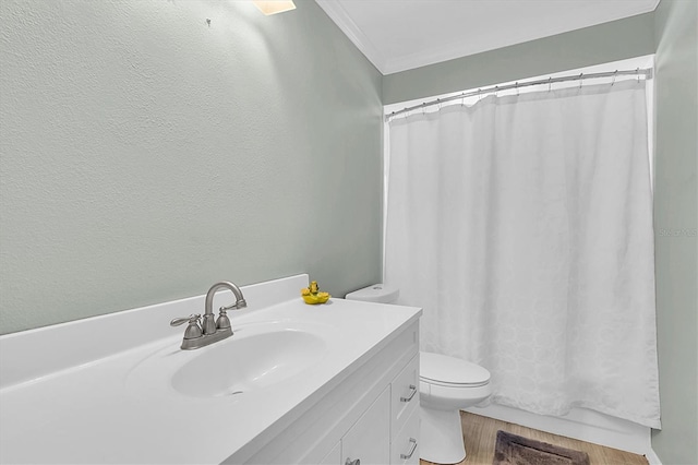 bathroom with vanity, toilet, wood finished floors, and crown molding