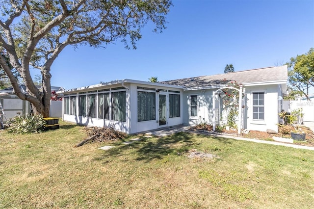 view of front facade featuring fence, a front lawn, and a sunroom