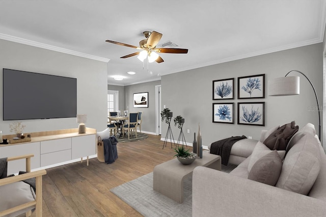 living area with a ceiling fan, crown molding, dark wood-style floors, and baseboards