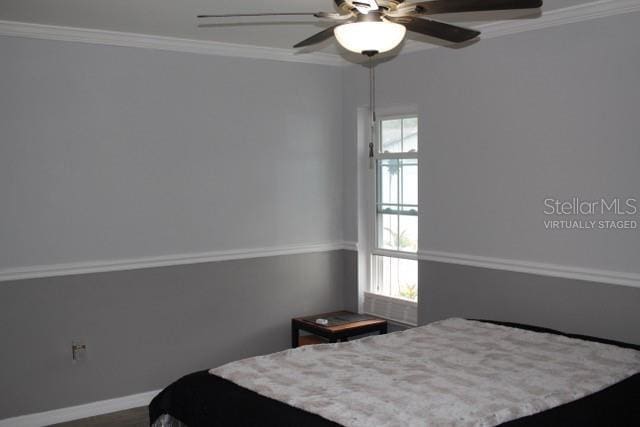 bedroom featuring a ceiling fan, crown molding, and baseboards