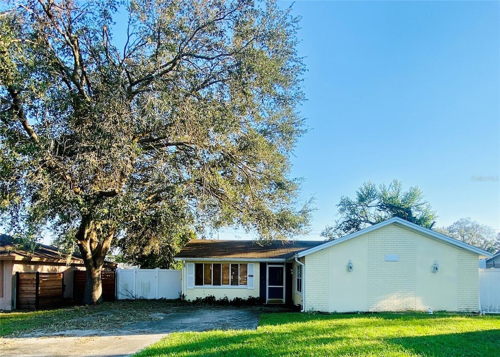 single story home featuring a front lawn