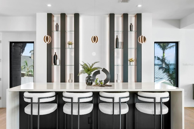 kitchen featuring light wood-type flooring, a breakfast bar area, and a large island with sink