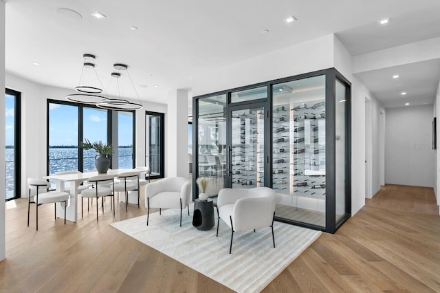 wine room with light hardwood / wood-style floors and an inviting chandelier