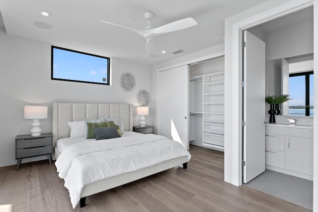 bedroom featuring light wood-type flooring, a closet, and ceiling fan