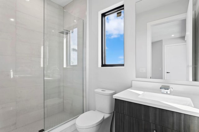 bathroom featuring tiled shower, vanity, and toilet