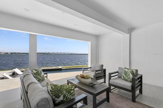 balcony with an outdoor living space, a water view, and a patio