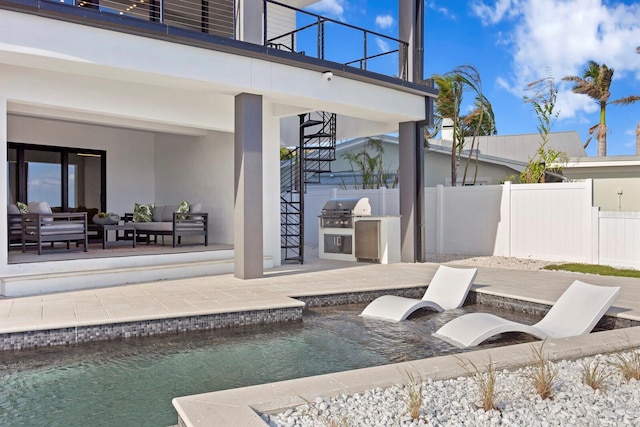 view of patio / terrace with an outdoor hangout area, a balcony, exterior kitchen, grilling area, and a fenced in pool