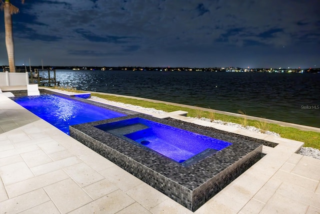 view of pool with a patio area, an in ground hot tub, and a water view