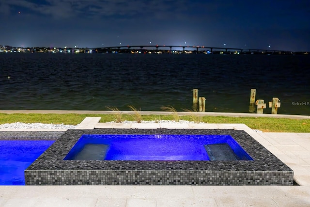 view of property's community featuring a pool with hot tub and a water view