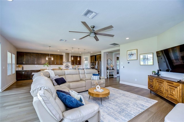 living room featuring light hardwood / wood-style floors, a wealth of natural light, and ceiling fan