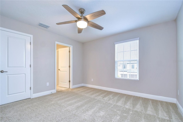 unfurnished bedroom with light colored carpet and ceiling fan