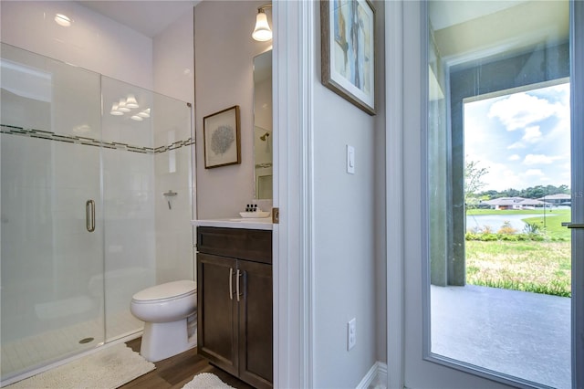 bathroom featuring hardwood / wood-style floors, vanity, toilet, and a shower with shower door