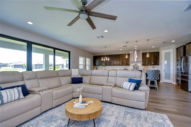 living room with ceiling fan and light hardwood / wood-style floors