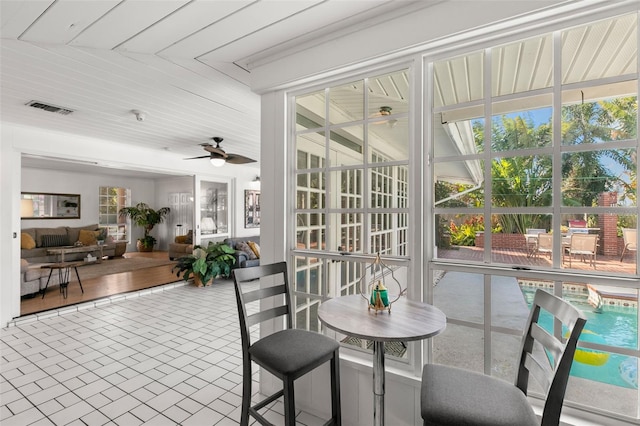 sunroom with ceiling fan and wood ceiling