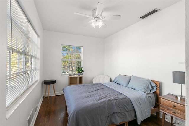 bedroom with multiple windows, ceiling fan, and dark wood-type flooring