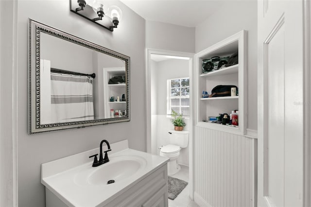 bathroom with tile patterned flooring, a shower with curtain, vanity, and toilet