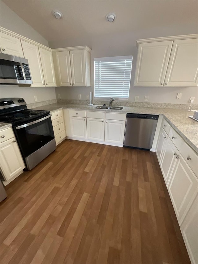 kitchen with dark wood-type flooring, white cabinets, and stainless steel appliances