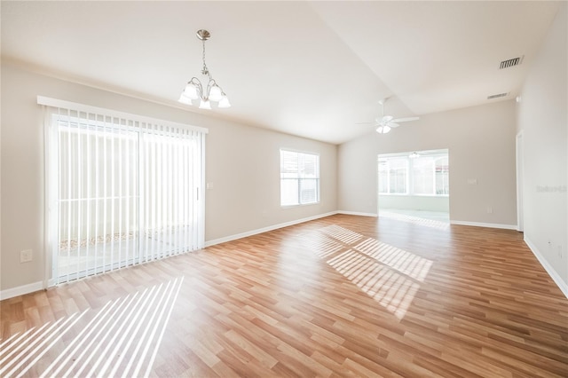 unfurnished room with lofted ceiling, light wood-type flooring, and ceiling fan with notable chandelier