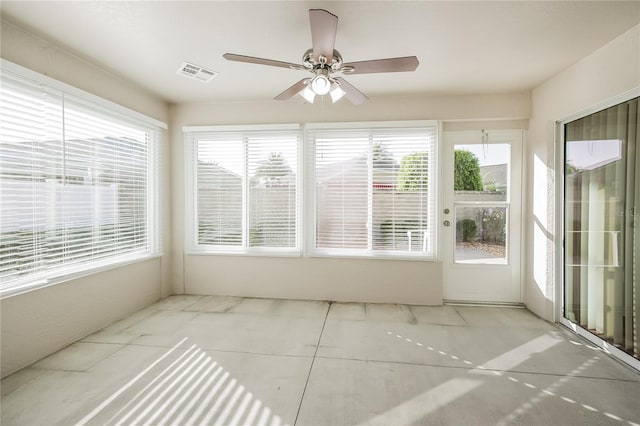 unfurnished sunroom with ceiling fan