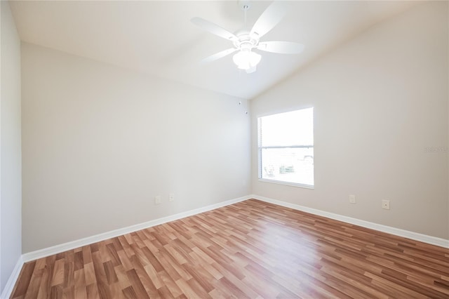 empty room with ceiling fan, light hardwood / wood-style floors, and vaulted ceiling