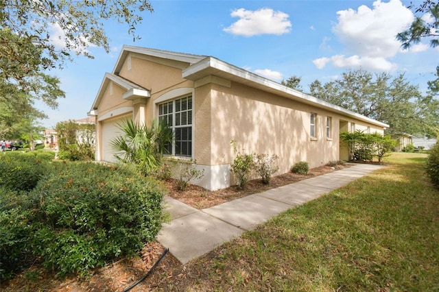 view of side of home with a lawn and a garage