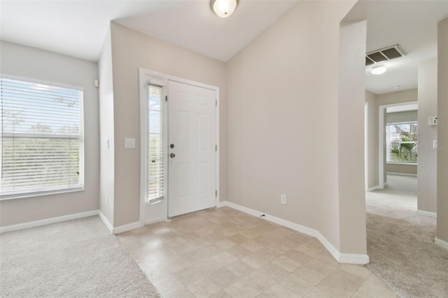 foyer with light colored carpet and a wealth of natural light