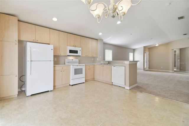 kitchen with light brown cabinets, white appliances, light colored carpet, kitchen peninsula, and a chandelier