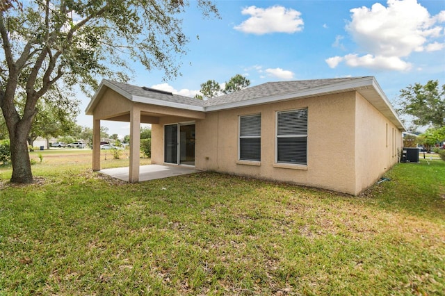 back of property with a yard and a patio